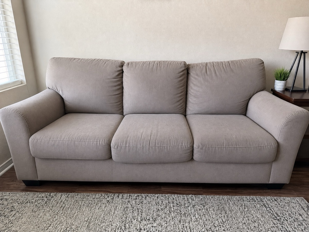 After: A three-cushion sofa with grimy arms and seats, then the same sofa after cleaning
