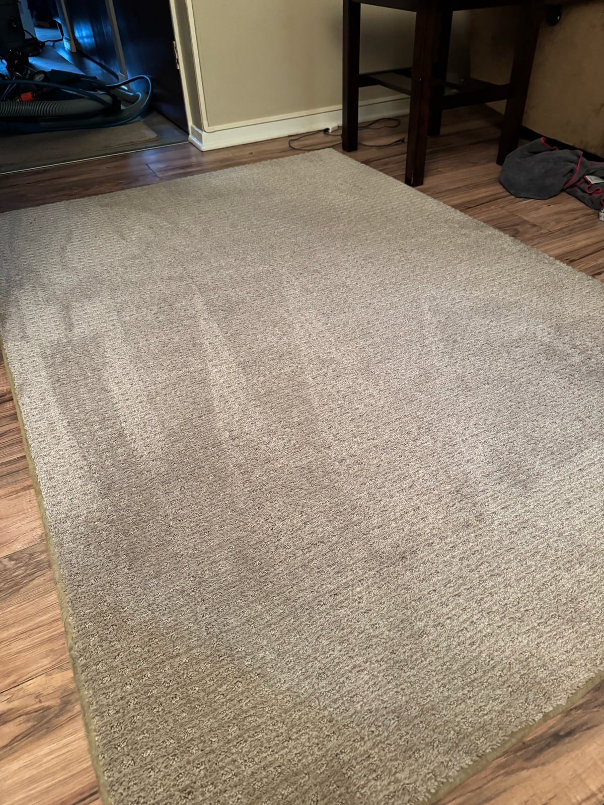 After: Light-colored area rug with visible traffic soil and spots, then the rug after cleaning