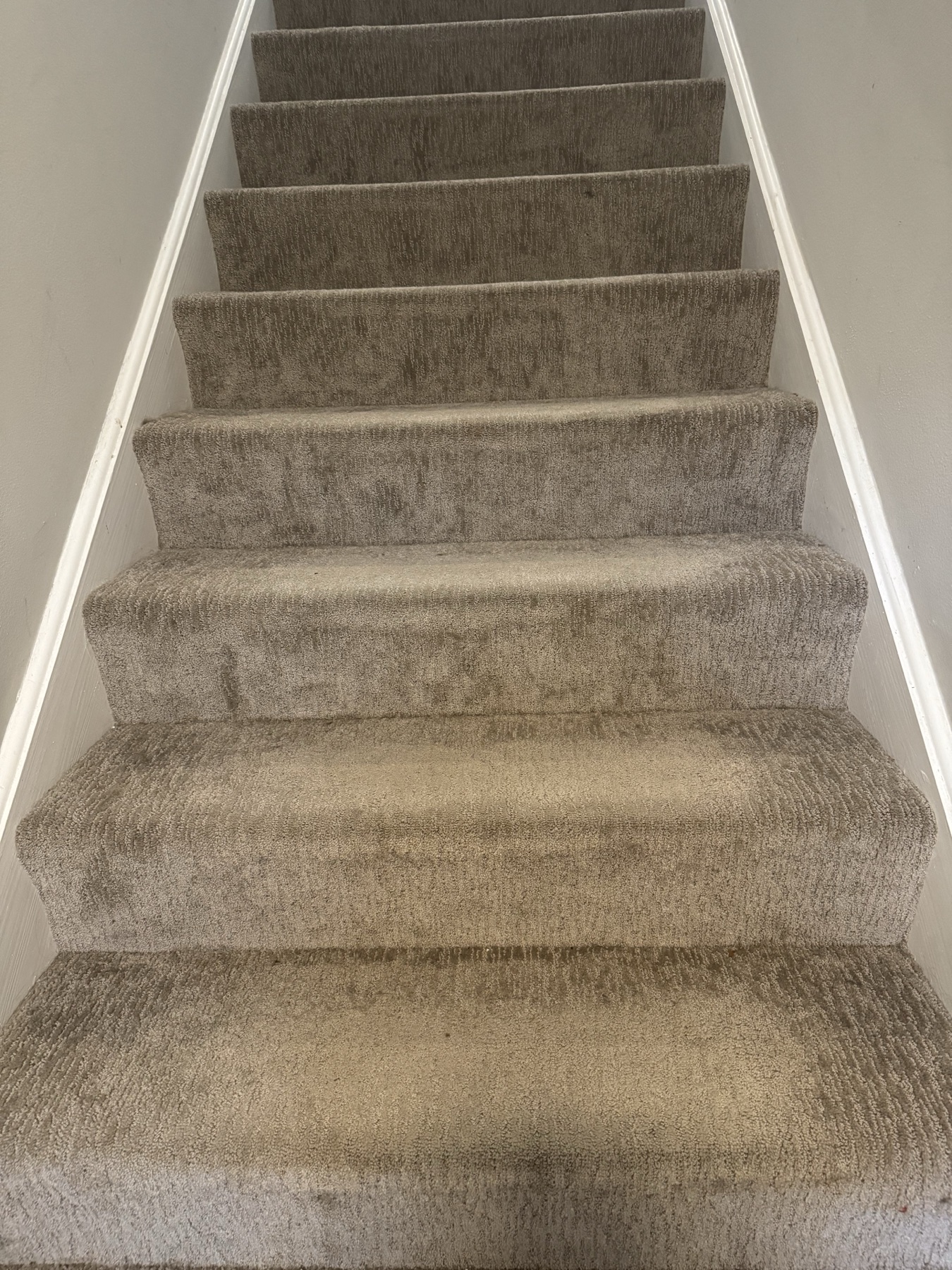 Before: Gray carpeted stairs with traffic soil across the treads and risers, then the same staircase after cleaning